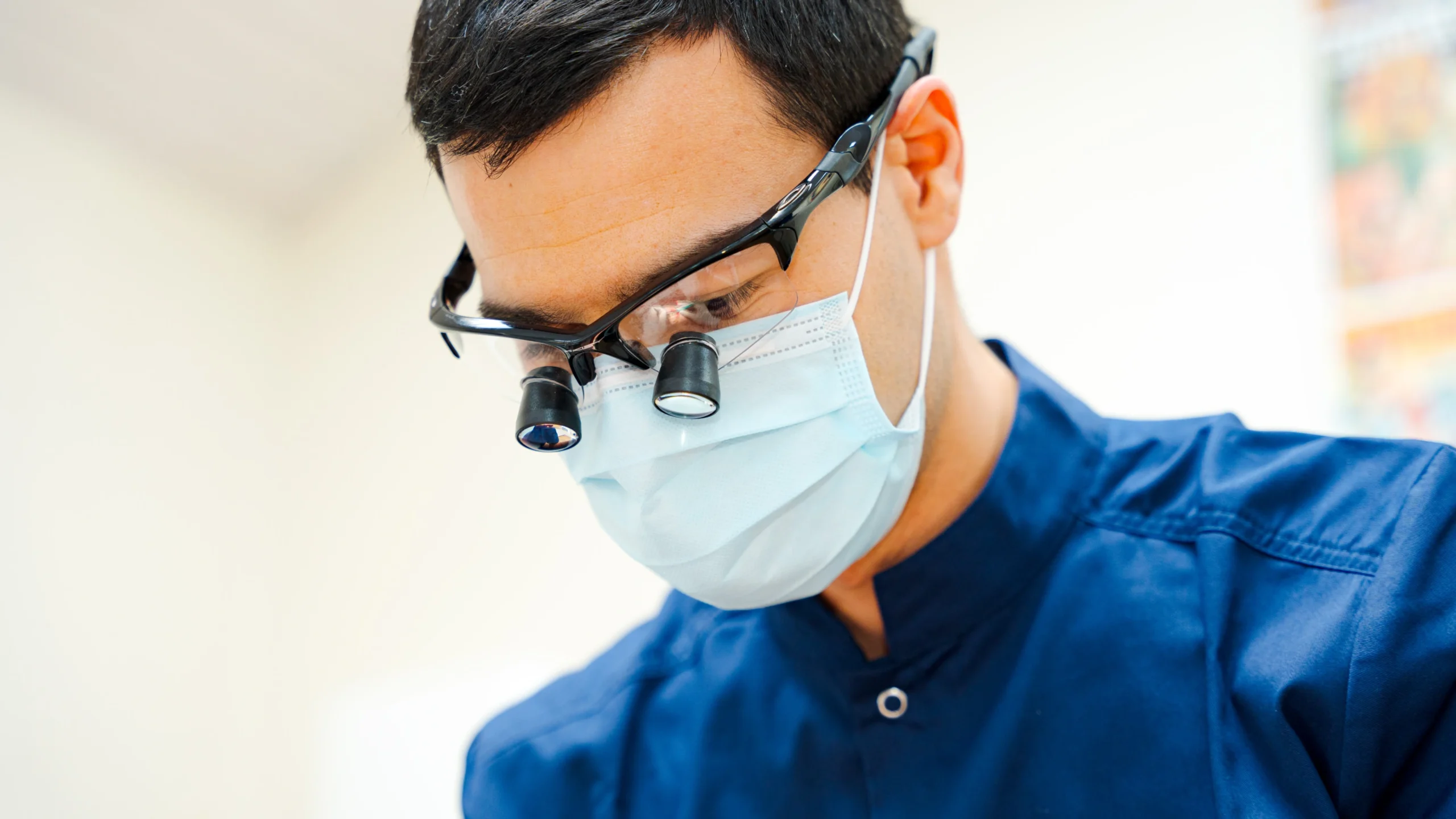 Dr Nicolas Clermont portant des loupes binoculaires et un masque pendant un soin d'orthodontie